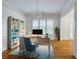 Bright home office with natural light, wood floors, chandelier, custom bookcase and blue accent chair at 3036 Lassiter Rd, Marietta, GA 30062