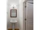 Classic powder room with a pedestal sink, wood-framed mirror and traditional sconce lighting at 3036 Lassiter Rd, Marietta, GA 30062
