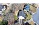 Aerial view of a two-story home surrounded by mature trees, green lawn, and a driveway, showcasing its setting at 1712 Green Farm Cir, Dacula, GA 30019