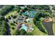 Overhead view of community amenities including pool, tennis courts, playground, and lush green spaces by a tranquil lake at 1712 Green Farm Cir, Dacula, GA 30019