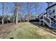 Spacious backyard with a well-maintained lawn, access to stairs, and bordered by mature trees and a privacy fence at 1712 Green Farm Cir, Dacula, GA 30019