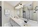 Bathroom featuring double sinks, white cabinets, a large mirror, and a glass-enclosed shower stall at 1712 Green Farm Cir, Dacula, GA 30019