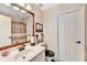 Well-lit bathroom with a wide mirror, single sink vanity, decorative accents, and a shower with a patterned curtain at 1712 Green Farm Cir, Dacula, GA 30019
