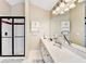 Bright bathroom featuring a double sink vanity, glass enclosed shower with dark trim, and ample counter space at 1712 Green Farm Cir, Dacula, GA 30019