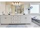 Well-lit bathroom with double sinks, a large mirror, ample vanity storage, and a separate soaking tub at 1712 Green Farm Cir, Dacula, GA 30019