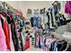 Organized walk-in closet with tiered shelving and hanging racks, filled with clothing and accessories at 1712 Green Farm Cir, Dacula, GA 30019