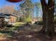 Spacious backyard with mature trees, a storage shed, and a small deck off the brick house at 239 Andrea Nw Cir, Lilburn, GA 30047
