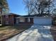 Charming brick home featuring a large driveway and a two-car garage, nestled among mature trees at 239 Andrea Nw Cir, Lilburn, GA 30047