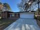 Charming brick home featuring a large driveway and a two-car garage, nestled among mature trees at 239 Andrea Nw Cir, Lilburn, GA 30047