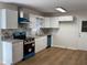 This newly renovated kitchen features white cabinets, granite countertops, and stainless appliances at 239 Andrea Nw Cir, Lilburn, GA 30047