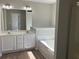 Primary bathroom featuring dual vanity sinks, soaking tub, and a separate shower at 295 Laurelton Cir, Lawrenceville, GA 30044