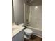 Bathroom featuring a white bathtub, shower, toilet, sink, and vanity against gray walls at 295 Laurelton Cir, Lawrenceville, GA 30044