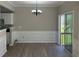 Dining area with wainscoting, stylish chandelier, and sliding glass door to the outside at 295 Laurelton Cir, Lawrenceville, GA 30044