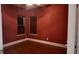 Bedroom with red walls, wood-look floors, and two windows at 460 Greystone Ln, Douglasville, GA 30134