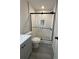 Bathroom with white subway tile, glass shower doors, and gray laminate wood flooring at 596 Windchase Ln, Stone Mountain, GA 30083