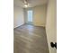 A room with gray laminate flooring, a ceiling fan, and a window at 596 Windchase Ln, Stone Mountain, GA 30083