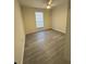 A room with gray laminate flooring, a ceiling fan, and a window at 596 Windchase Ln, Stone Mountain, GA 30083