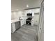 Modern kitchen featuring stainless steel appliances, quartz countertops, and gray laminate flooring at 596 Windchase Ln, Stone Mountain, GA 30083