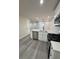 Bright kitchen featuring stainless steel appliances, quartz countertops, and gray laminate flooring at 596 Windchase Ln, Stone Mountain, GA 30083