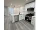 Bright kitchen featuring stainless steel appliances, quartz countertops, and gray laminate flooring at 596 Windchase Ln, Stone Mountain, GA 30083
