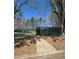 View of the playground and tennis court surrounded by mature trees and fencing at 596 Windchase Ln, Stone Mountain, GA 30083
