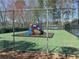 Community playground and tennis court surrounded by a tall fence and mature trees at 596 Windchase Ln, Stone Mountain, GA 30083