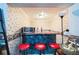 Basement bar area with red bar stools, a microwave, diner-themed wallpaper, and black countertop at 1490 Highland Lake Dr, Lawrenceville, GA 30045