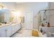 Main bathroom with double sinks, white tile flooring, gold hardware, and a separate shower at 1490 Highland Lake Dr, Lawrenceville, GA 30045