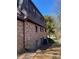 Side view of brick home showcasing dark exterior and a well-maintained landscaped area at 285 Old College Way, Atlanta, GA 30328