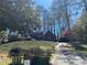 Charming single-Gathering home featuring mature landscaping, brick details, and a private driveway at 285 Old College Way, Atlanta, GA 30328