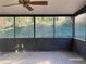 Relaxing screened patio with a ceiling fan and views of the lush green backyard at 285 Old College Way, Atlanta, GA 30328