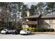 Two-story townhome with a private balcony, chimney, neutral paint scheme, and ample parking spaces for residents and guests at 401 Woodcliff Dr, Atlanta, GA 30350