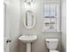 Cozy half bathroom with a pedestal sink, oval mirror and window with lots of natural light at 4718 Wehunt Se Trl # 20, Smyrna, GA 30082