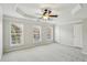 Spacious main bedroom featuring tray ceilings, a ceiling fan, and three large windows that provide natural light at 4718 Wehunt Se Trl # 20, Smyrna, GA 30082