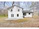 Home's backyard features a concrete patio surrounded by mature trees and natural landscaping at 6730 Alvan Ct, Riverdale, GA 30296