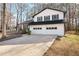 Charming two-story home with a long driveway and a two-car garage, nestled amongst mature trees at 6730 Alvan Ct, Riverdale, GA 30296