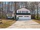 Charming two-story home featuring a covered porch, a two-car garage, and a well-manicured lawn at 6730 Alvan Ct, Riverdale, GA 30296