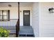 Inviting front porch with gray painted wood, black railing, and a charming entry door at 6730 Alvan Ct, Riverdale, GA 30296