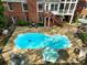 An aerial shot highlights a beautiful pool area, patio and screened in porch of this backyard at 1544 Blue Bird Way, Cumming, GA 30041