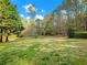 Expansive backyard with lush green grass, mature trees, and landscaping at 1544 Blue Bird Way, Cumming, GA 30041