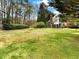 Expansive backyard with lush lawn and mature trees, perfect for outdoor activities at 1544 Blue Bird Way, Cumming, GA 30041