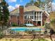 An expansive backyard showcasing a refreshing swimming pool, a patio, and an upper screened porch at 1544 Blue Bird Way, Cumming, GA 30041