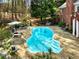 Overhead view of a backyard featuring a free-form pool, stone patio, lounge furniture, and grassy surroundings at 1544 Blue Bird Way, Cumming, GA 30041