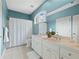 Light blue bathroom includes double sinks, white cabinetry and trim, shower/tub combo and a window at 1544 Blue Bird Way, Cumming, GA 30041