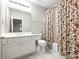 Well-lit bathroom with a shower/tub combo and floral shower curtain at 1544 Blue Bird Way, Cumming, GA 30041