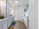 Well-lit bathroom featuring double vanity with light gray cabinetry and an integrated tub/shower at 1544 Blue Bird Way, Cumming, GA 30041