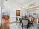 Open dining area featuring chandelier, hardwood floors, and access to kitchen at 1544 Blue Bird Way, Cumming, GA 30041
