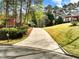 Long driveway leading to a charming home with lush landscaping and mature trees at 1544 Blue Bird Way, Cumming, GA 30041