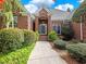 A welcoming brick home with a charming entrance featuring a blue front door and meticulously maintained landscaping at 1544 Blue Bird Way, Cumming, GA 30041
