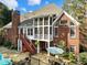 Backyard view of this two story brick home featuring a pool, hot tub, screened porch and stone patio at 1544 Blue Bird Way, Cumming, GA 30041